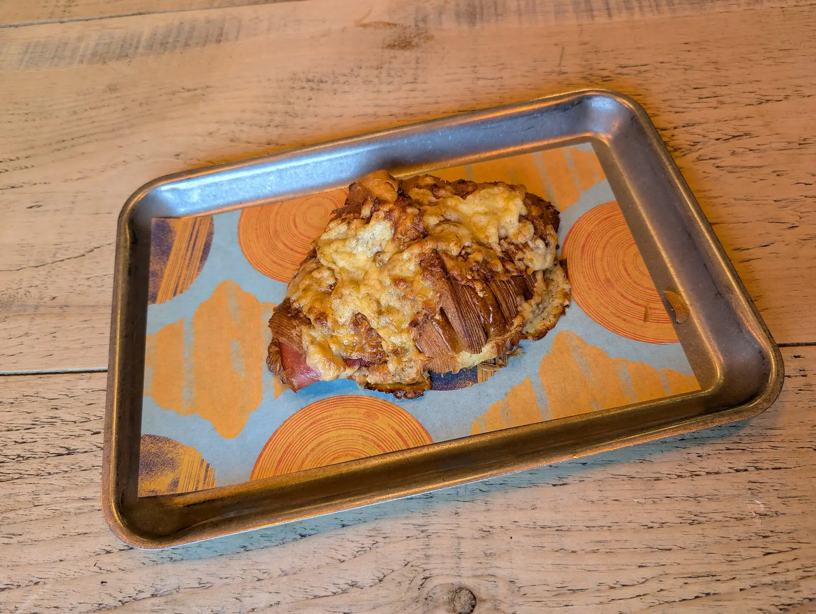 A ham and cheese croissant on a bakery tray. The photo was not taken in Brookhaven.